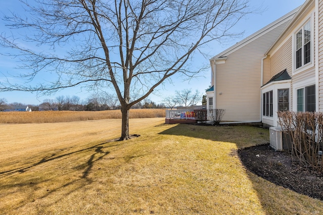 view of yard with central AC unit and a wooden deck