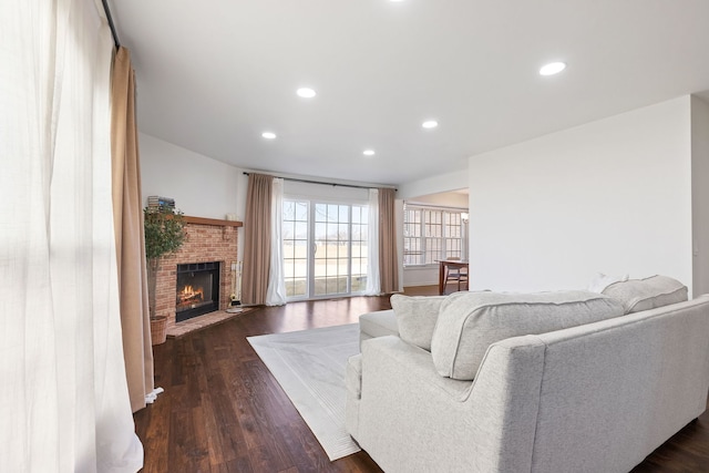 living area featuring recessed lighting, a fireplace, and dark wood-type flooring