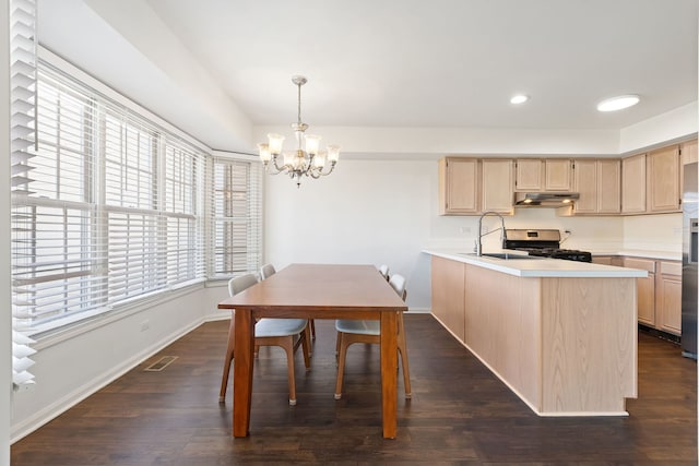 kitchen with visible vents, under cabinet range hood, light brown cabinetry, an inviting chandelier, and stainless steel appliances