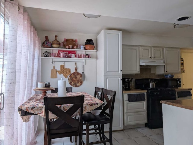 kitchen featuring light tile patterned floors, decorative backsplash, under cabinet range hood, black appliances, and open shelves