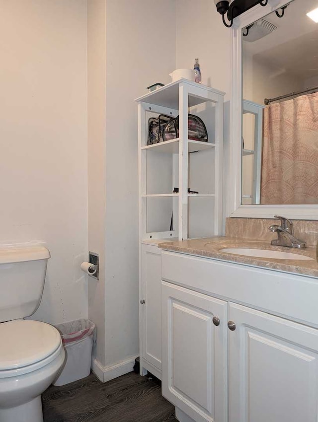 full bath featuring baseboards, vanity, toilet, and wood finished floors