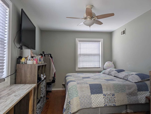 bedroom featuring ceiling fan, dark wood finished floors, visible vents, and baseboards