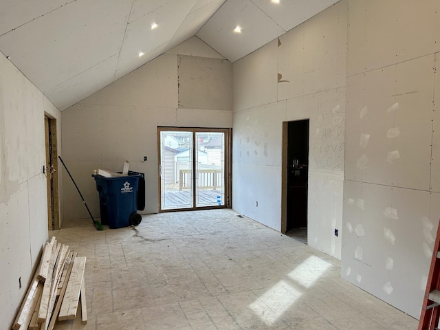 spare room featuring light floors and high vaulted ceiling