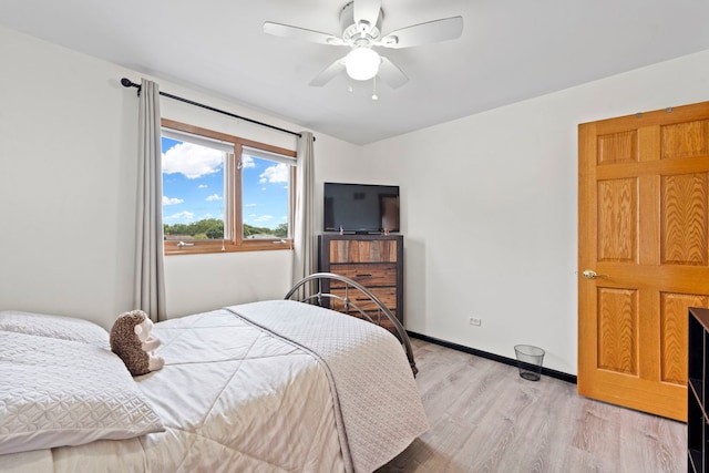 bedroom featuring ceiling fan, light wood-style flooring, and baseboards