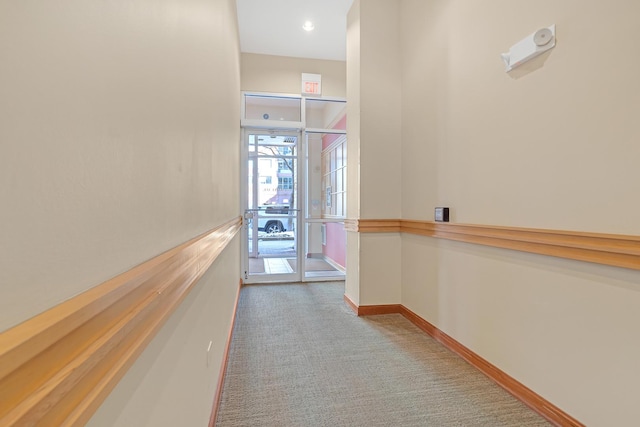 corridor with light carpet and baseboards