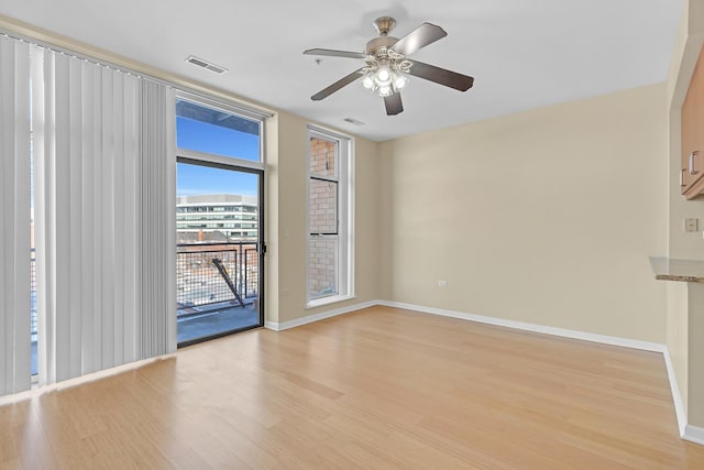 unfurnished room with baseboards, ceiling fan, visible vents, and light wood-style floors