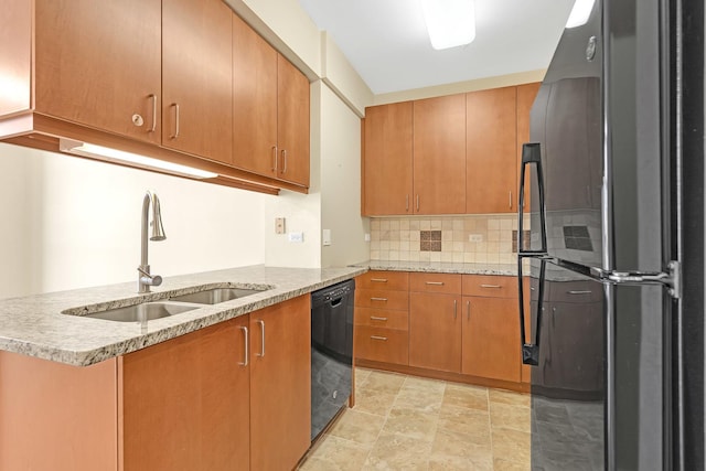 kitchen with tasteful backsplash, brown cabinetry, a sink, a peninsula, and black appliances