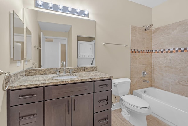 full bath featuring toilet, shower / bath combination, vanity, and stacked washer and clothes dryer