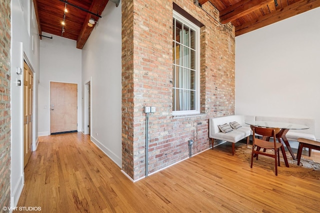 hallway with wood finished floors, beam ceiling, and wooden ceiling