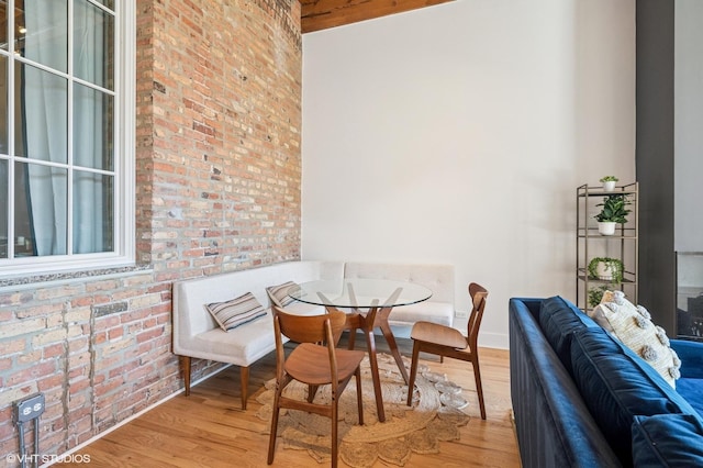 interior space with wood finished floors and brick wall