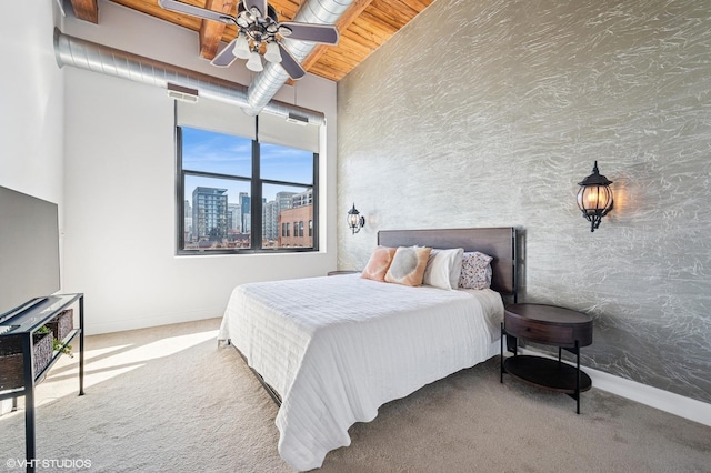 carpeted bedroom with baseboards, a high ceiling, a city view, and wooden ceiling