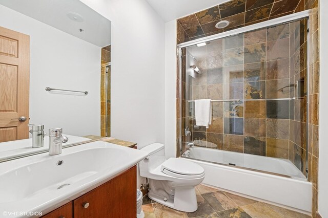 bathroom featuring vanity, toilet, and enclosed tub / shower combo