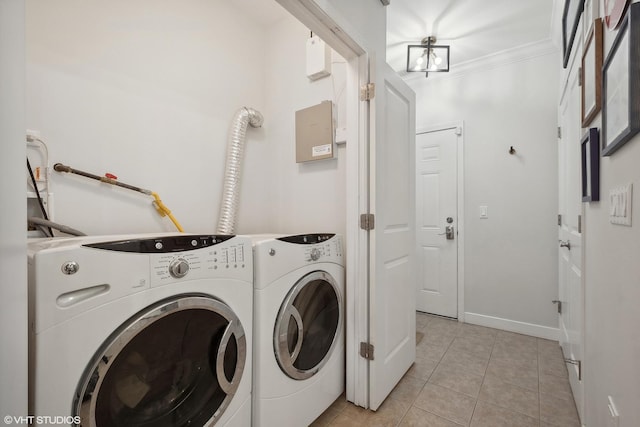 clothes washing area featuring washing machine and clothes dryer, baseboards, ornamental molding, laundry area, and light tile patterned flooring