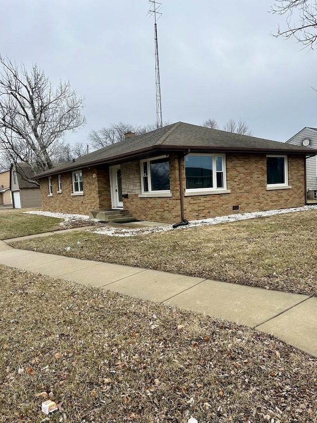 single story home featuring brick siding, an outdoor structure, a chimney, and a front lawn