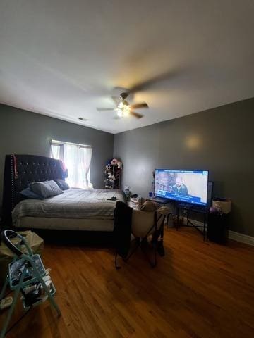 bedroom with ceiling fan, dark wood finished floors, and baseboards