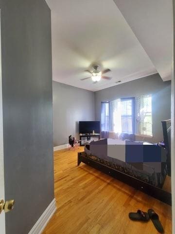 bedroom with ceiling fan, baseboards, and wood finished floors