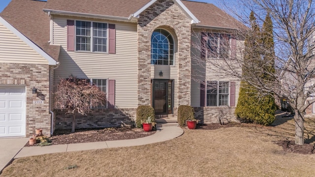 view of front of house featuring a shingled roof, brick siding, and a garage