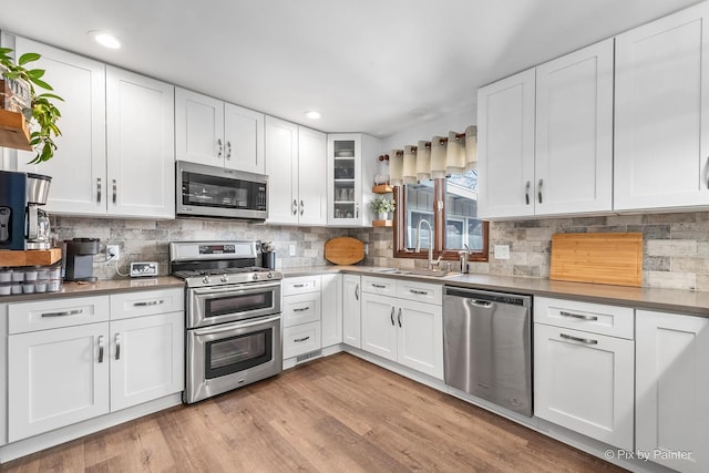 kitchen featuring appliances with stainless steel finishes, backsplash, and a sink