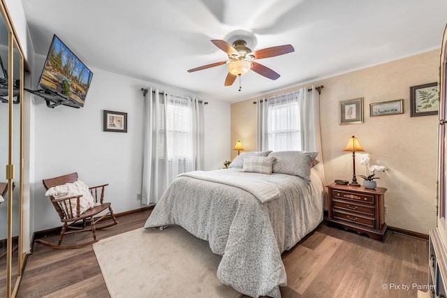 bedroom with ceiling fan, baseboards, and wood finished floors