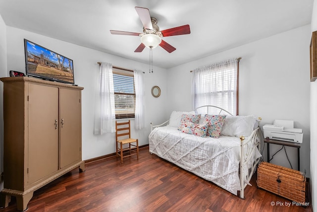 bedroom featuring multiple windows, wood finished floors, a ceiling fan, and baseboards