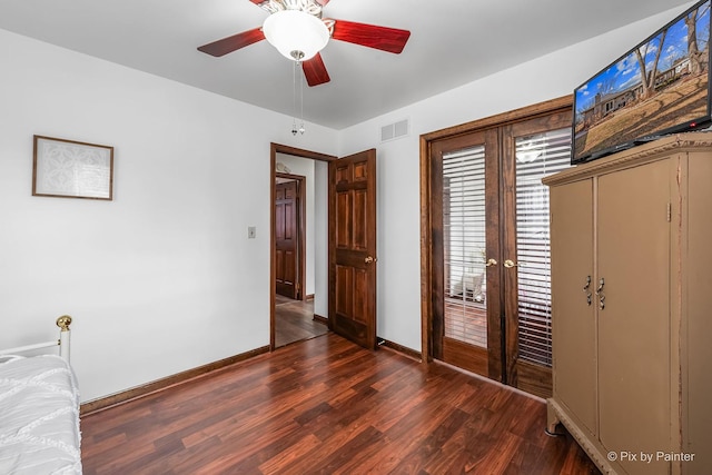 unfurnished bedroom with french doors, dark wood-style flooring, visible vents, and baseboards