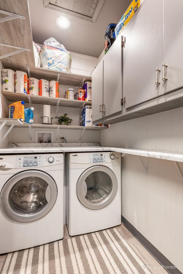 laundry area with separate washer and dryer and cabinet space