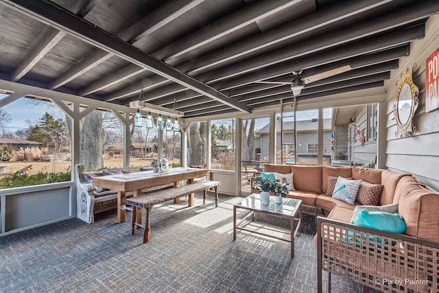 sunroom featuring beamed ceiling and ceiling fan