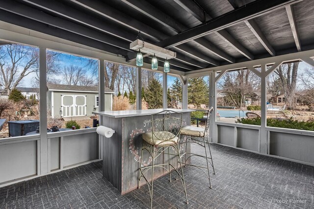 sunroom / solarium featuring plenty of natural light and beam ceiling