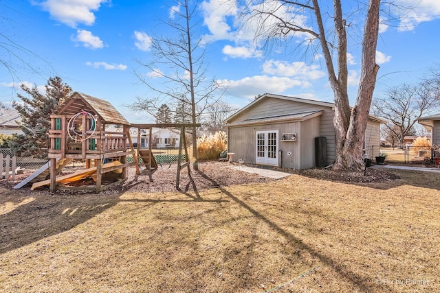 back of house with french doors, a playground, and fence