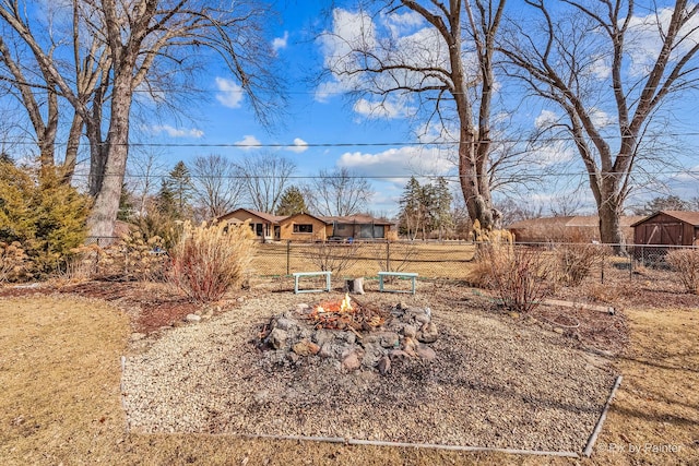 view of yard with a fire pit and fence