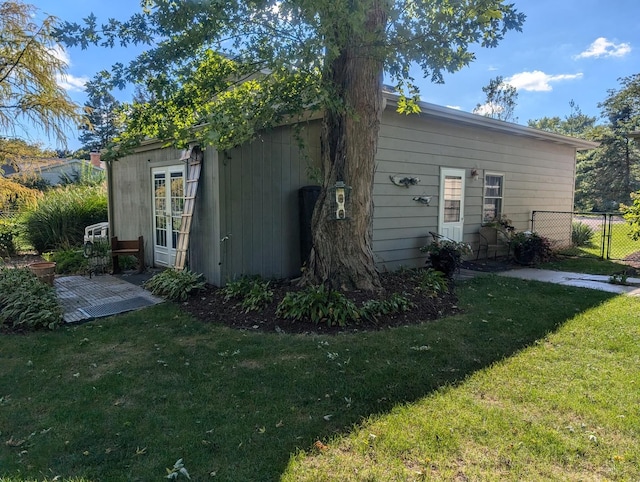 back of property featuring fence and a yard