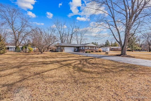 single story home featuring a garage, a front yard, and driveway