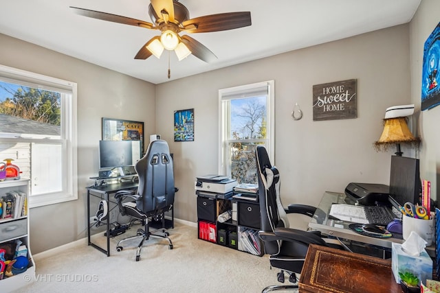 carpeted home office with baseboards, a ceiling fan, and a wealth of natural light