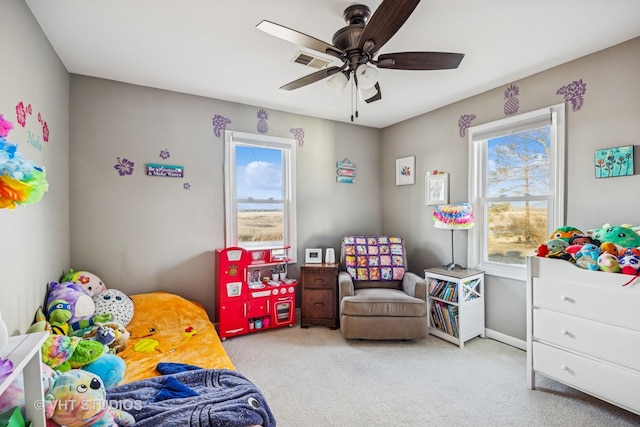 bedroom featuring carpet floors, a ceiling fan, visible vents, and multiple windows