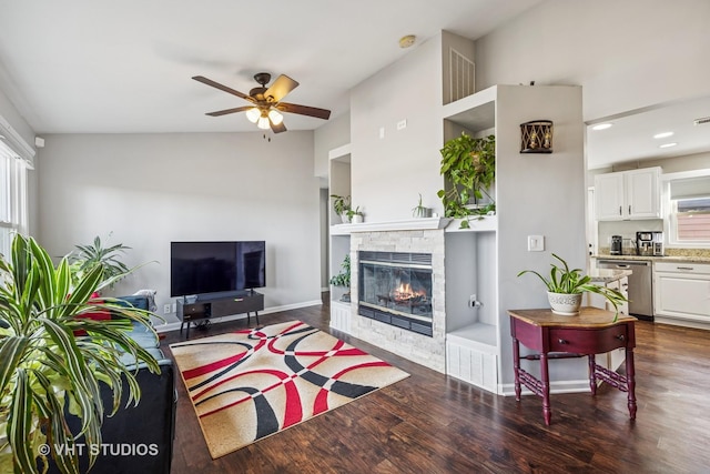 living area with ceiling fan, a fireplace, baseboards, and dark wood-style flooring