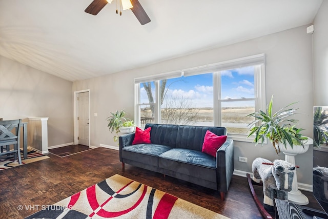 living area featuring a ceiling fan, baseboards, and wood finished floors