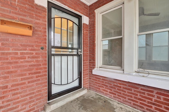 view of exterior entry with brick siding