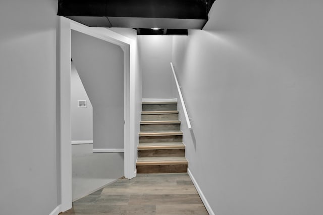 stairway featuring baseboards and wood finished floors