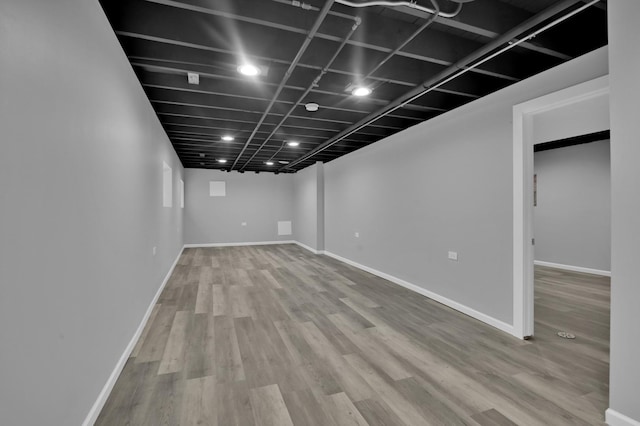 finished basement featuring baseboards and wood finished floors