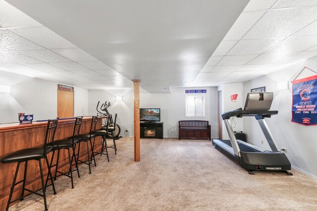 bar with carpet floors, a dry bar, visible vents, stairway, and a glass covered fireplace