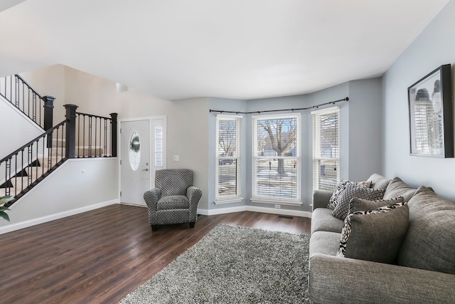 sitting room with stairs, wood finished floors, and baseboards