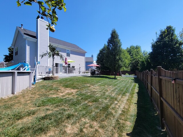 back of property with a deck, an outbuilding, a chimney, and a shed