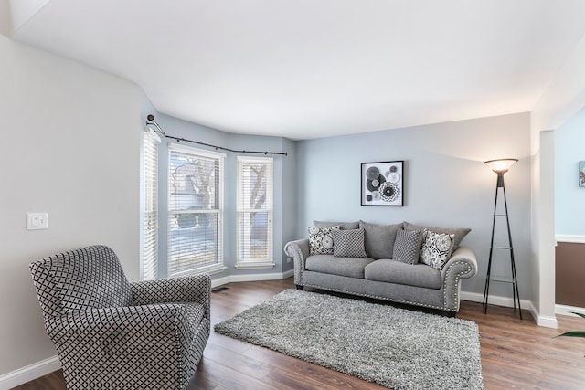 living area featuring wood finished floors, visible vents, and baseboards