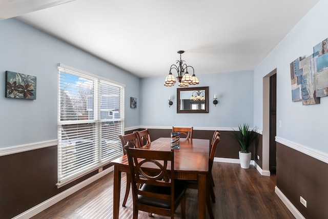 dining area featuring a chandelier, wood finished floors, and baseboards