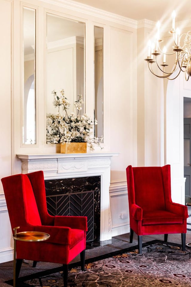 living area with a premium fireplace, ornamental molding, and a decorative wall