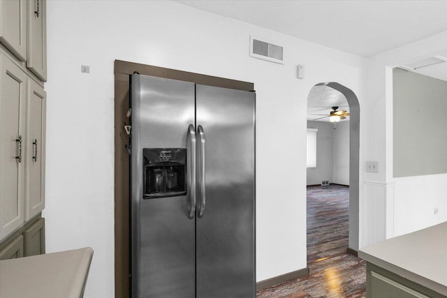 kitchen featuring visible vents, stainless steel refrigerator with ice dispenser, ceiling fan, dark wood finished floors, and wainscoting