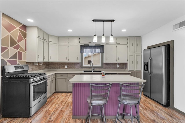 kitchen with light wood-style flooring, light countertops, visible vents, appliances with stainless steel finishes, and a sink