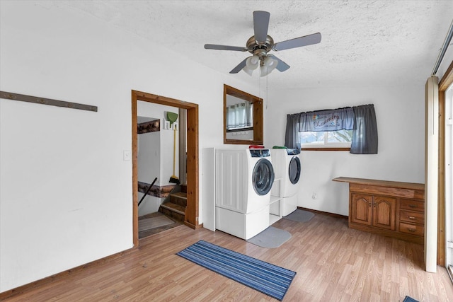 clothes washing area with light wood-style flooring, a textured ceiling, a ceiling fan, and washer and clothes dryer