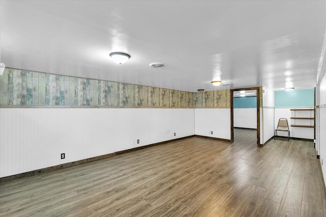 spare room featuring wood finished floors, baseboards, and visible vents