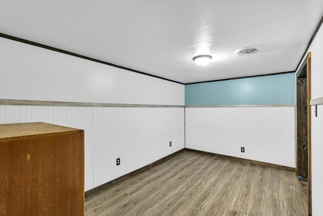 interior space featuring wainscoting, visible vents, and wood finished floors